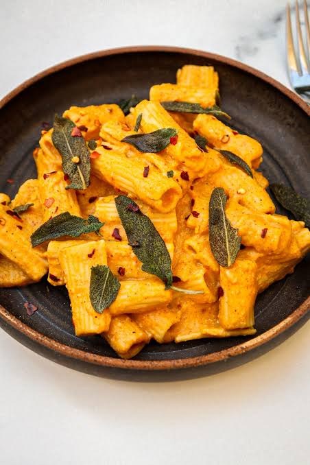 Creamy vegan pumpkin pasta with sage and pumpkin seeds in a bowl