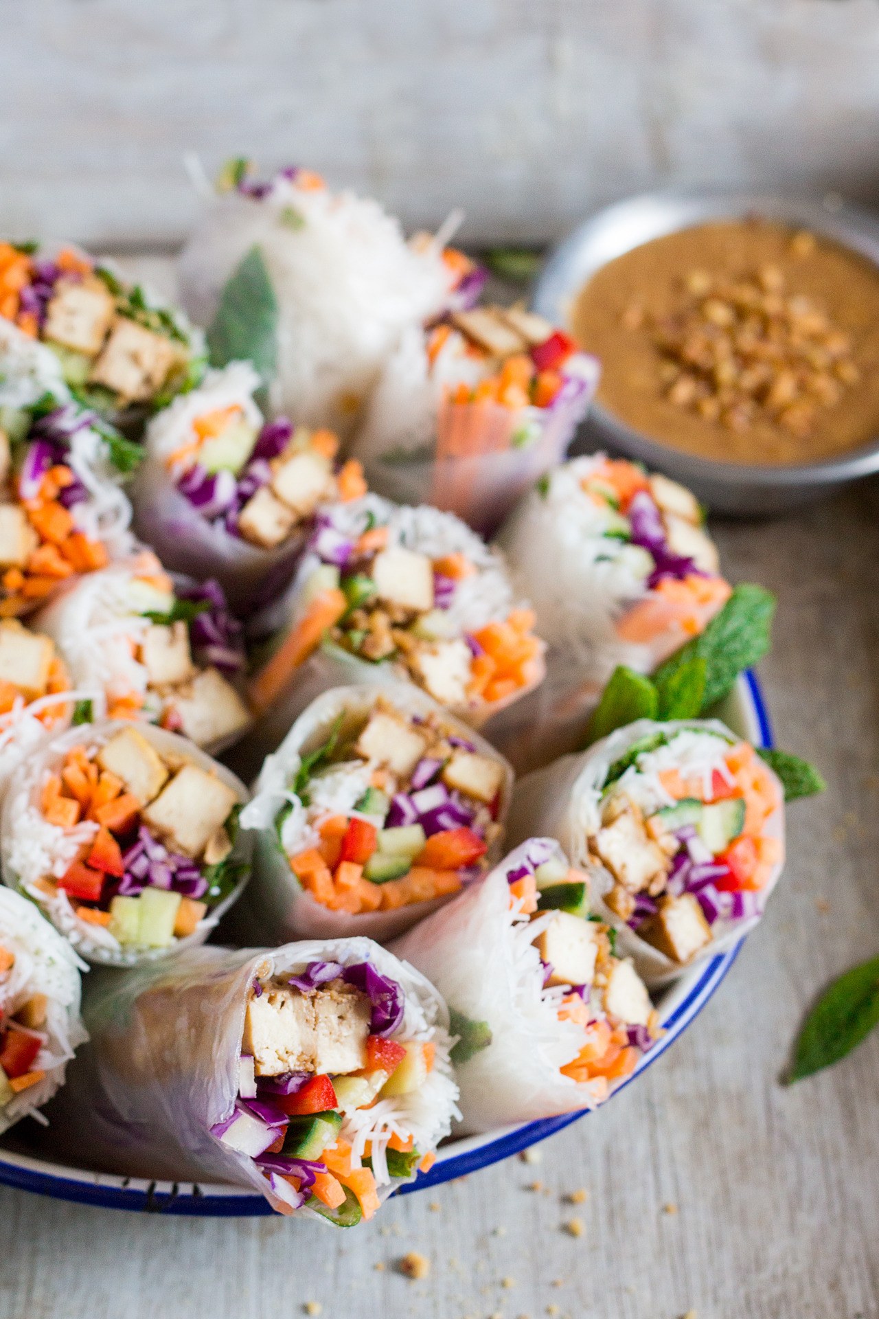 Tempeh satay rice paper rolls filled with vegetables and served with peanut sauce