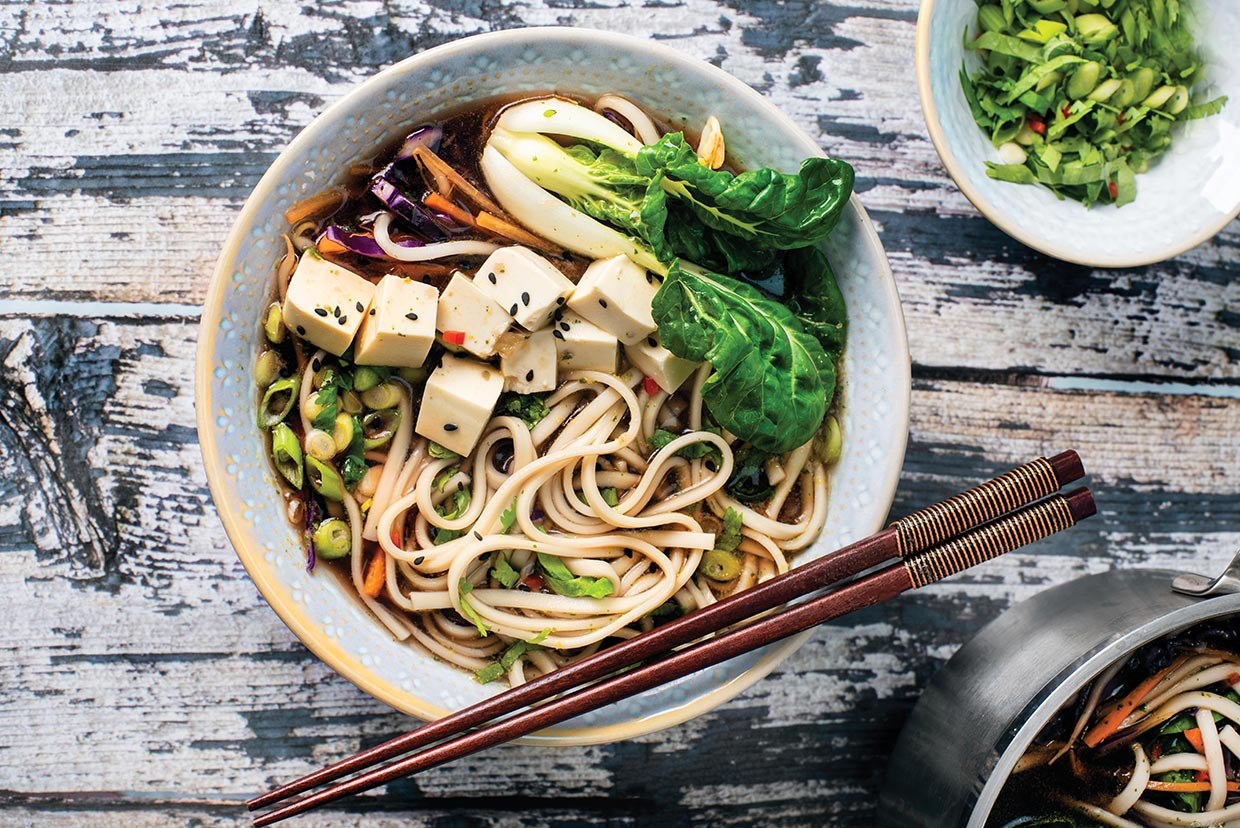 Vegan miso and ginger udon noodle soup with vegetables and spring onions