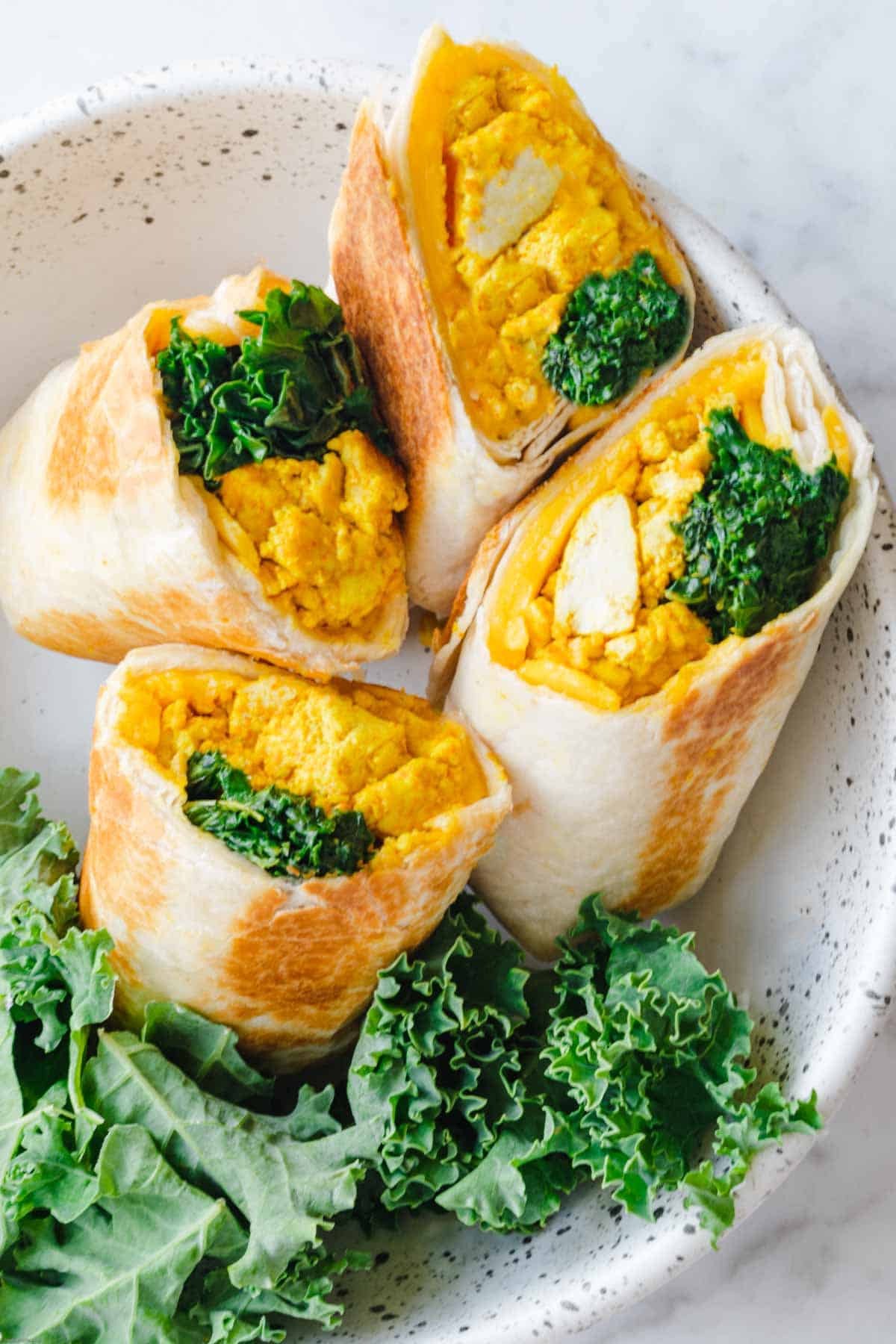 Vegan tofu scramble wrap with sautéed vegetables and guacamole
