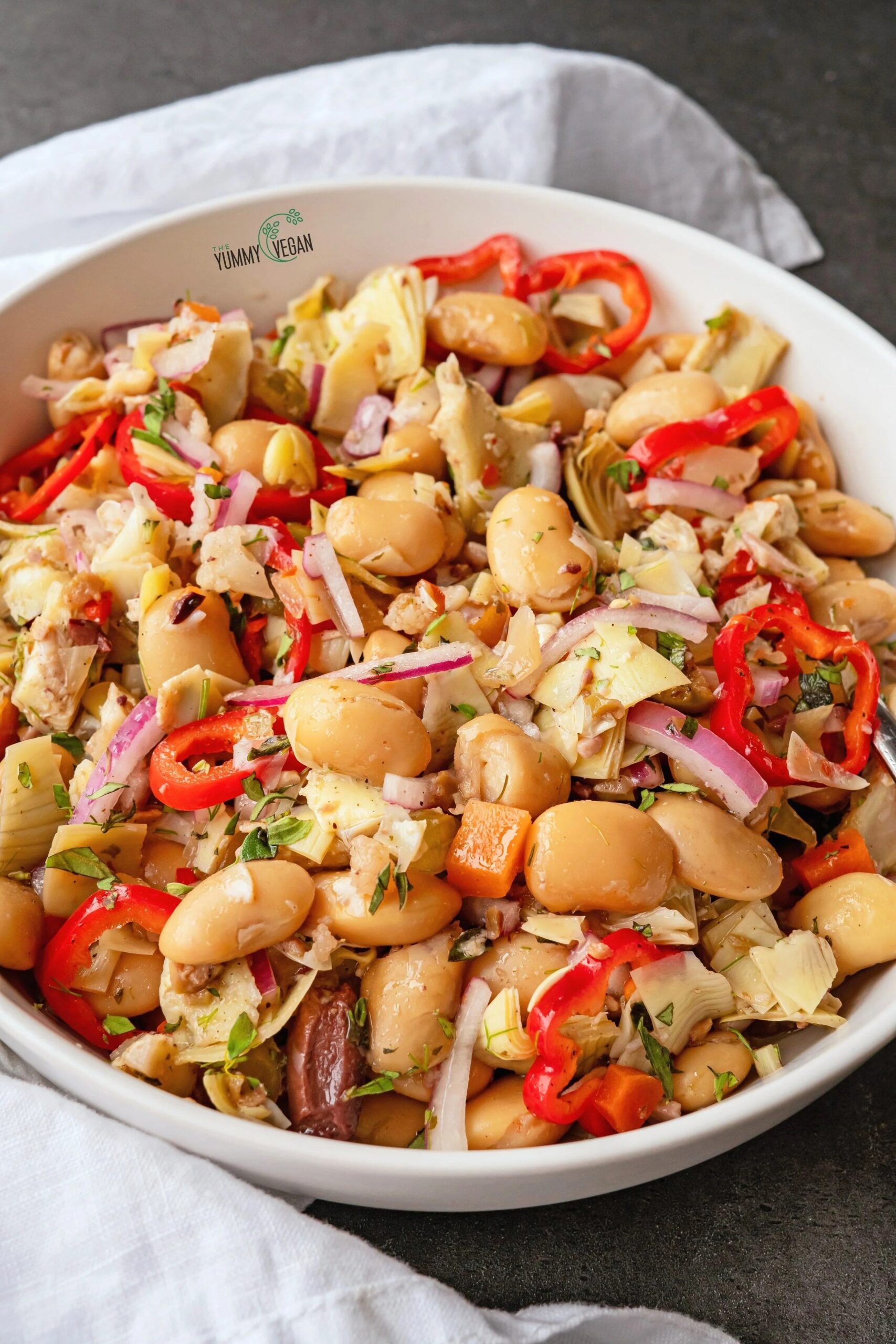 Bowl of couscous and mixed bean salad with diced red pepper and fresh parsley