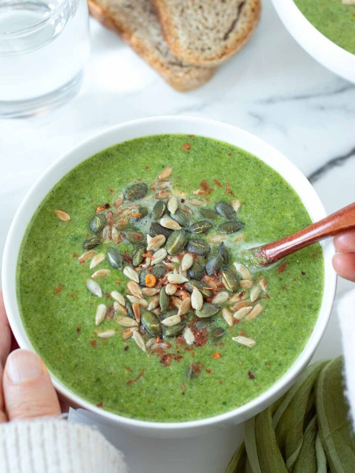 Bright green pea, spinach and mint soup served in a bowl